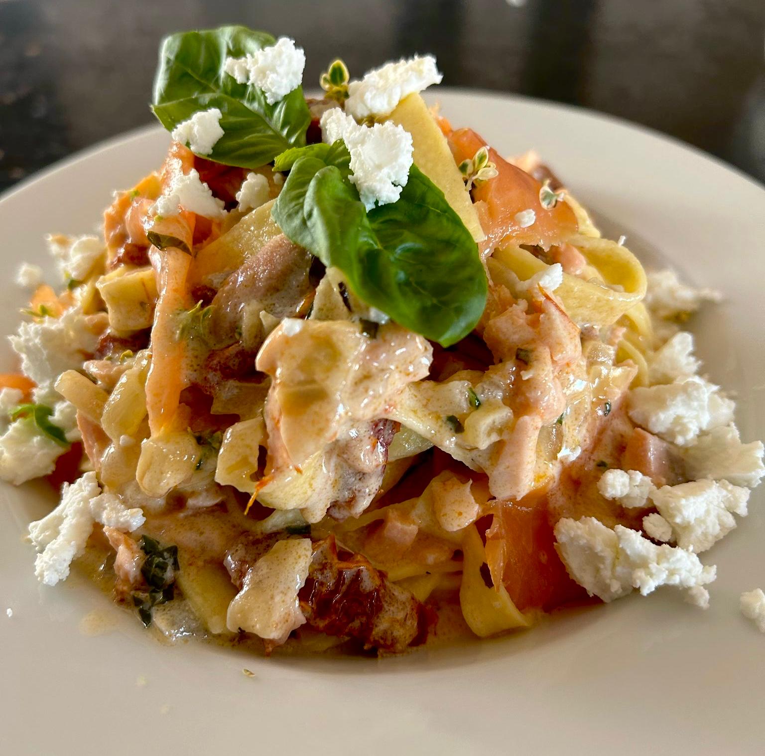 Pasta with smoked salmon, sun-dried tomatoes and goat cheese in creamy sauce